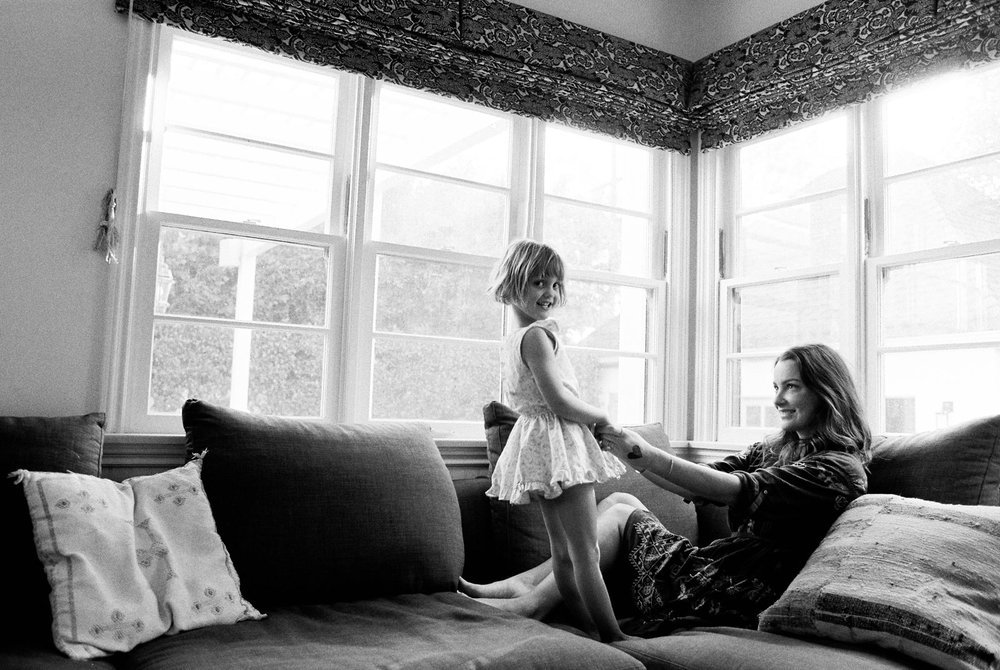mother and daughter playing on couch at home