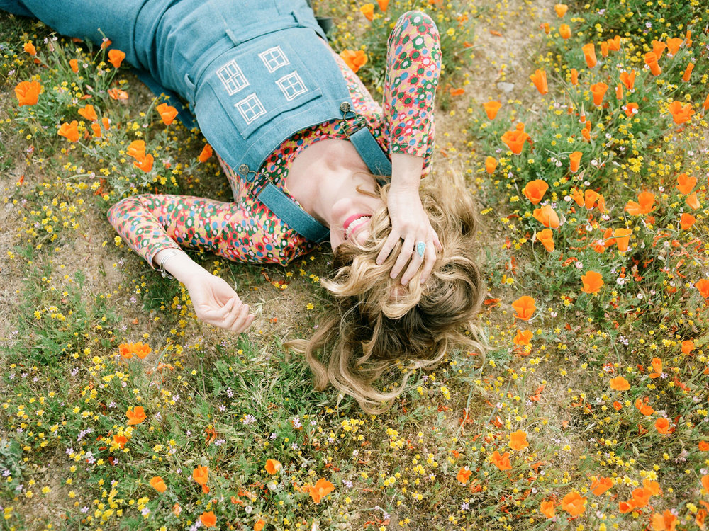 A woman laying down in a field of flowers.