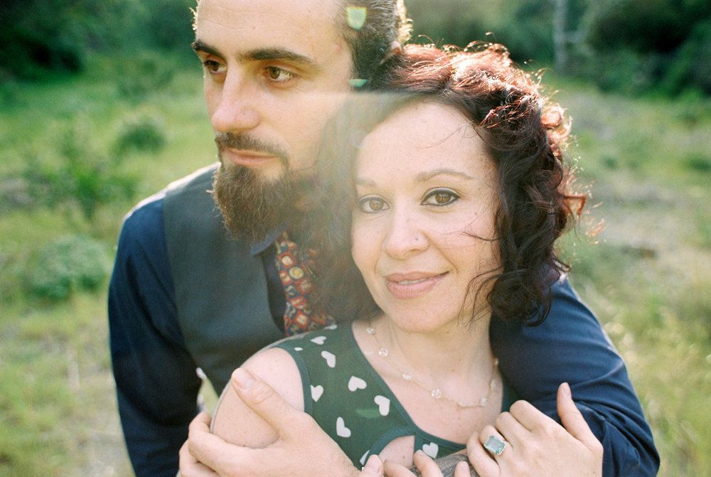 A man and woman hugging in a field.