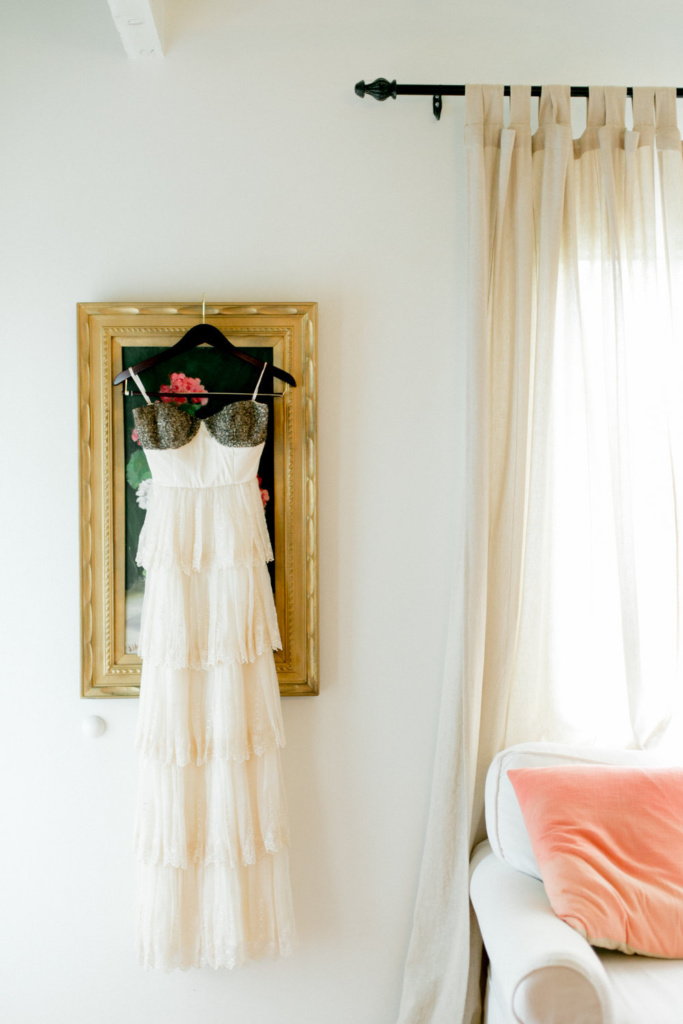 A dress hangs on a hanger in a room.