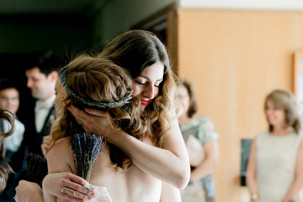 A woman is hugging another woman during a wedding ceremony.