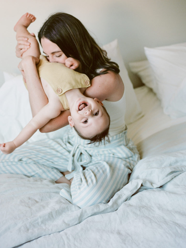 mothers kissing young songs belly playfully in bed