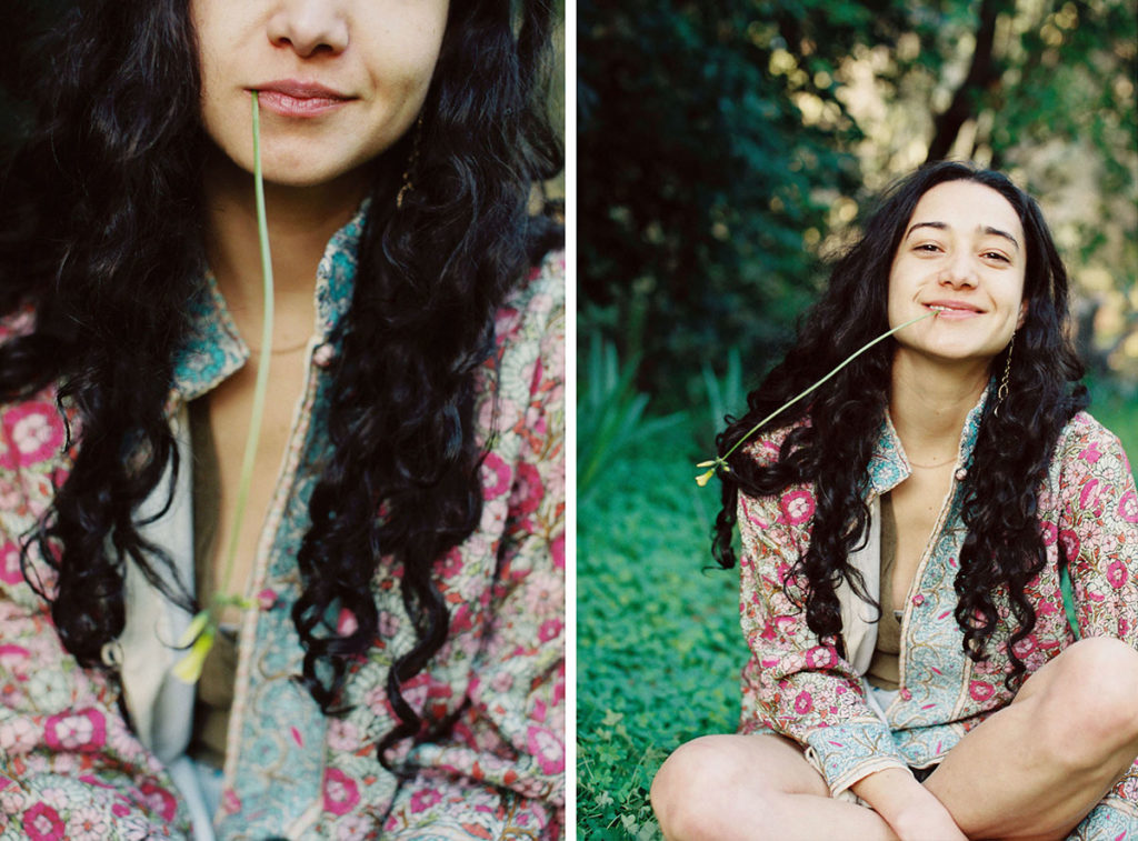 young woman smiling outdoors with sweetgrass in her mounth