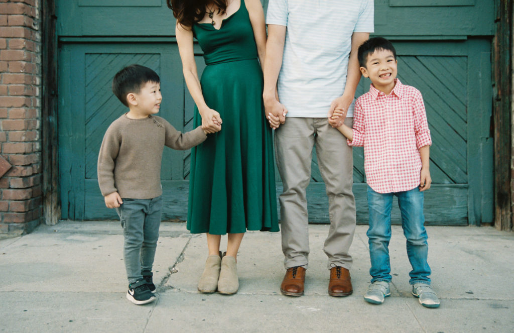 family of four in a city with focus on 2 young and smiling boys