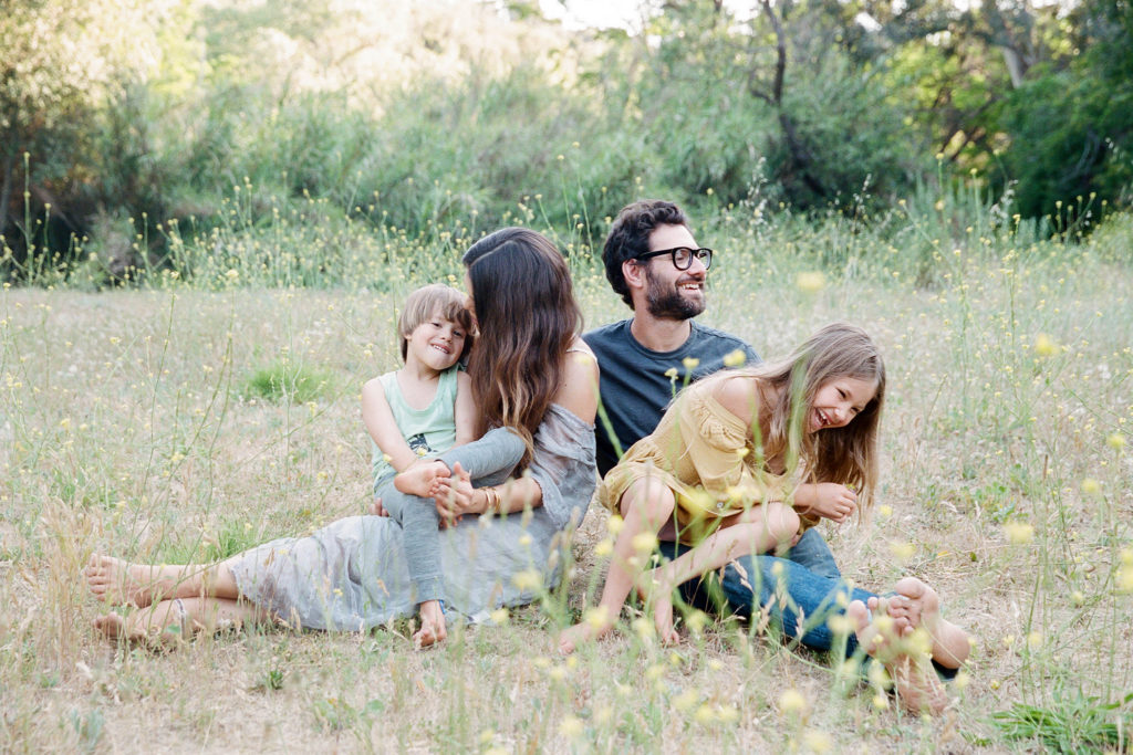 family of four interaction in a flowery field