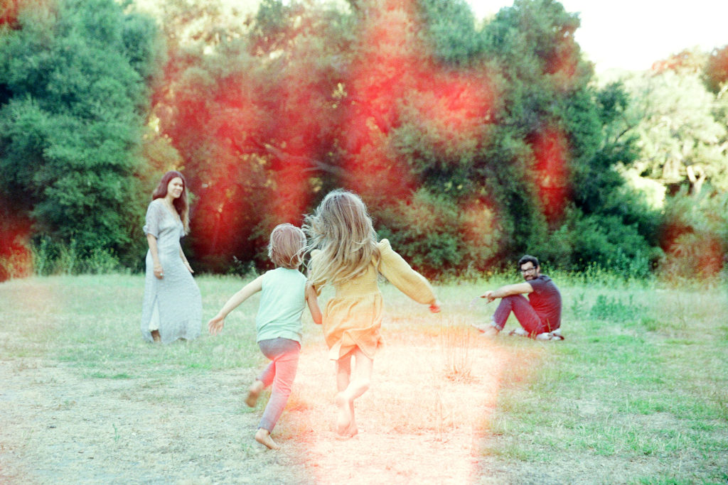 kids running towards parents in a field 