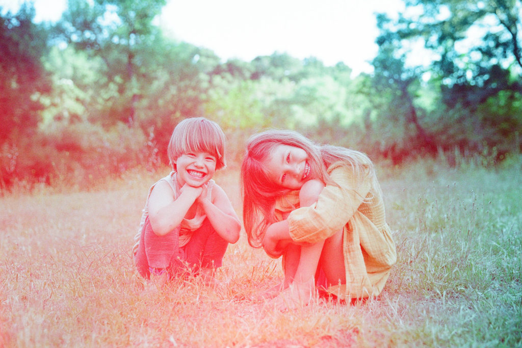 colorful film photo of smiling siblings