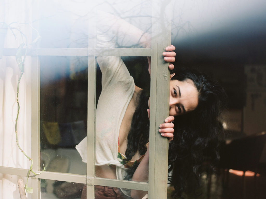 A woman peeking out of a window.