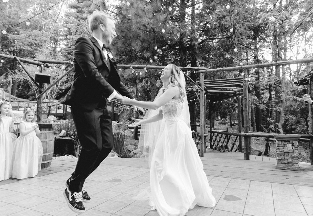 A bride and groom jumping in the air at their wedding.