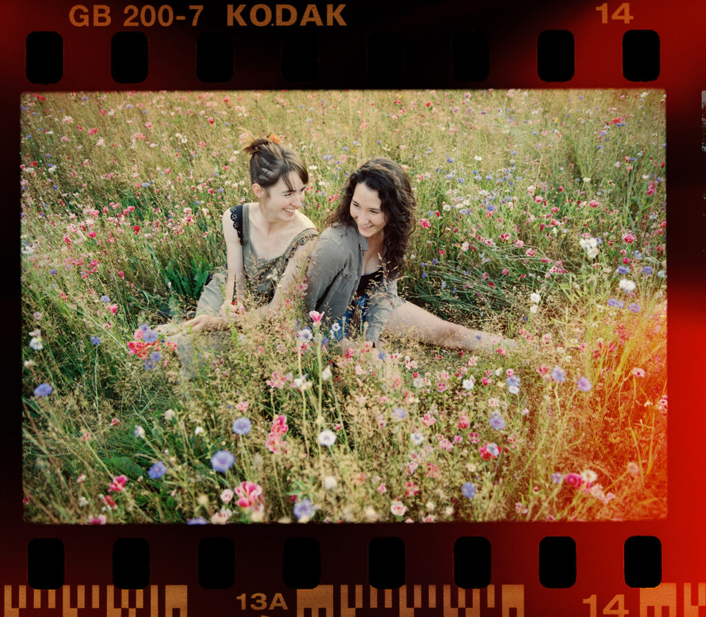2 young woman laughing in a flower fields