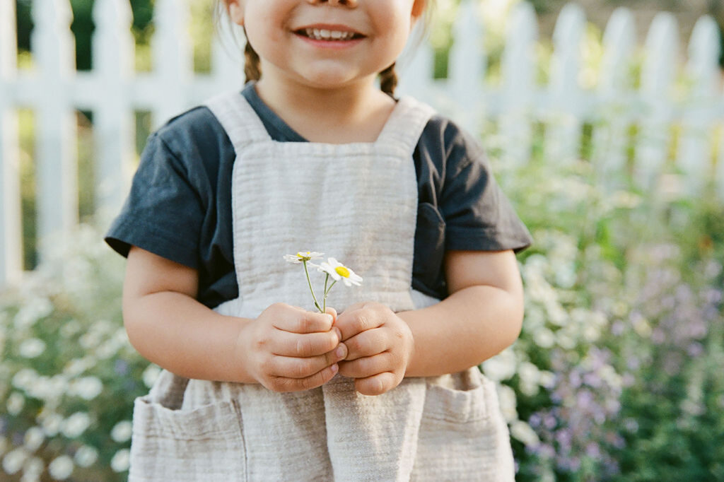 close up of toddler holding little flowers
