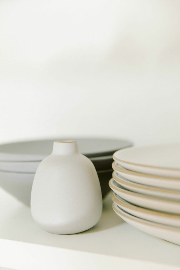 Neatly arranged ceramic tableware on a shelf.