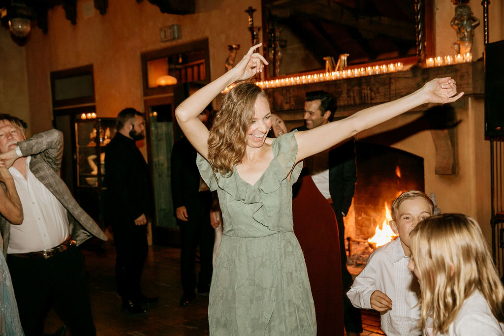 Woman dancing with arms raised in a festive atmosphere.