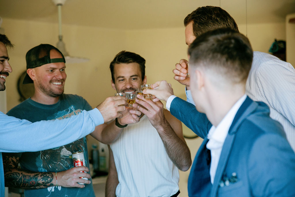A group of men toasting with drinks in a celebratory gathering.