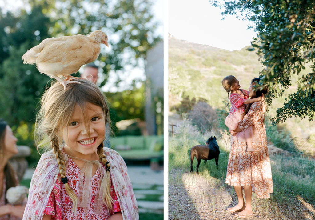 A young girl smiles with a chicken on her head, while a woman holds a child nearby, with a pony in the background.
